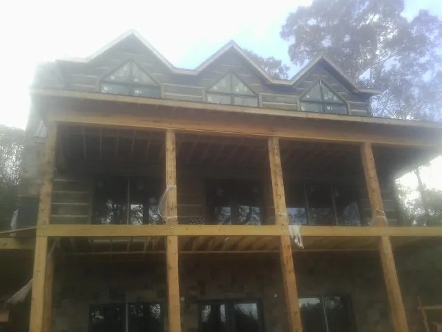 Dormers and porch framing on a large log home under construction — Roof Coating work by our crew in Bemidji