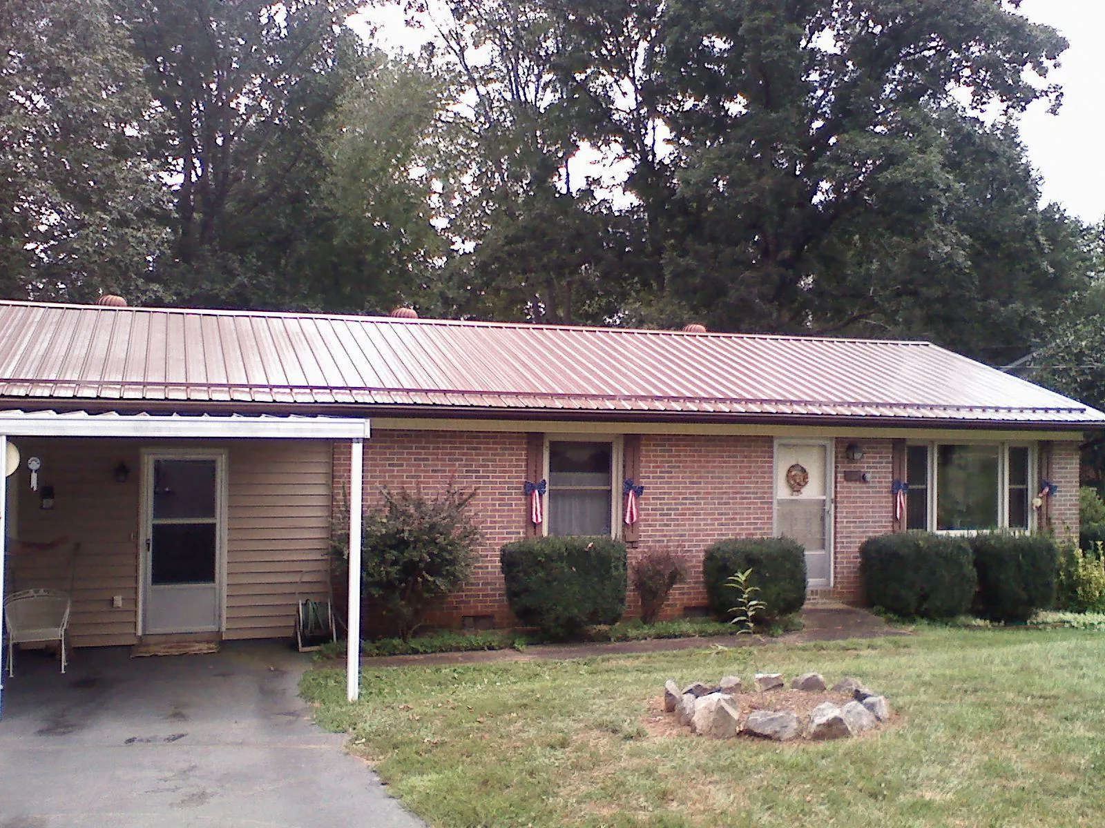 Bronze metal roof and carport on a brick ranch home — Roof Repair work by our crew in Bemidji
